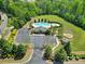 Aerial view of a community pool area, featuring a clover-shaped pool, playground, parking and grassy lawn at 5025 Willing Ct, Fort Mill, SC 29707