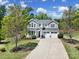 Beautiful two-story home showcasing a long driveway, lush landscaping, and an inviting front porch at 5025 Willing Ct, Fort Mill, SC 29707