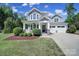 Charming two-story home with a covered porch, two-car garage, manicured lawn and tasteful landscaping at 5025 Willing Ct, Fort Mill, SC 29707