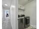 Hall laundry area features modern washer and dryer units with convenient overhead shelving at 5025 Willing Ct, Fort Mill, SC 29707