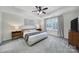 Bright main bedroom boasts tray ceilings, plantation shutters, and stylish, modern furnishings at 5025 Willing Ct, Fort Mill, SC 29707