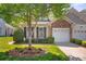 Charming home featuring a one car garage, a stone facade, and beautiful landscaping and manicured lawn at 512 Park View Dr, Belmont, NC 28012