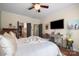 Well-lit main bedroom with a ceiling fan, walk-in closets, an ensuite, and hardwood floors at 512 Park View Dr, Belmont, NC 28012