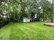 Manicured backyard featuring a storage shed, lush lawn, and an expansive lawn at 5621 Landale Ct, Concord, NC 28027