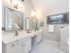 Spa-like bathroom with dual sinks, vanity, and a decorative mirror at 5621 Landale Ct, Concord, NC 28027