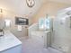 Bright bathroom with a soaking tub, glass-enclosed shower, and double vanity at 5621 Landale Ct, Concord, NC 28027