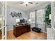 Bright office featuring a large wooden desk, hardwood floors, and decorative art on the light gray walls at 575 Marthas View Nw Dr, Huntersville, NC 28078