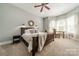 Sunlit main bedroom with a decorative mirror, upholstered headboard, and a comfortable seating area at 5868 Savona Ter, Fort Mill, SC 29708