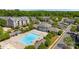 Aerial view featuring a community pool, clubhouse, and surrounding residences with mature trees at 5908 Glassport Ln, Charlotte, NC 28210