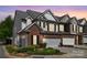 Charming townhome boasts a brick facade, attached garage, and professionally landscaped front yard at 5908 Glassport Ln, Charlotte, NC 28210