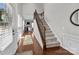 Inviting foyer featuring hardwood floors, staircase with iron spindles, and natural light at 5908 Glassport Ln, Charlotte, NC 28210