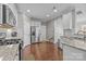The kitchen features a stainless steel refrigerator, white cabinets, granite countertops, and hardwood floors at 5908 Glassport Ln, Charlotte, NC 28210