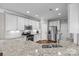 Bright kitchen features white cabinets, granite countertops, stainless steel appliances, and hardwood floors at 5908 Glassport Ln, Charlotte, NC 28210