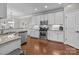 This kitchen features stainless steel appliances, white cabinetry, granite countertops, and hardwood floors at 5908 Glassport Ln, Charlotte, NC 28210
