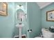 Stylish powder room with a pedestal sink, decorative mirror, and modern toilet at 5908 Glassport Ln, Charlotte, NC 28210