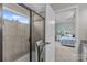 Stylish walk-in shower with sleek black trim and tile surround, viewed from the bedroom doorway at 5908 Glassport Ln, Charlotte, NC 28210