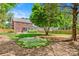 Spacious backyard featuring an artificial putting green, mature trees, and a wood fence at 6201 Creola Rd, Charlotte, NC 28270