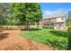 Lush backyard with green grass, mature trees, and a view of the two-story home at 6201 Creola Rd, Charlotte, NC 28270