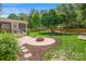 Landscaped backyard with a brick fire pit, stone walkway, and small putting green at 6201 Creola Rd, Charlotte, NC 28270