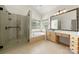 Bathroom features a large soaking tub, glass enclosed shower and maple cabinetry at 6201 Creola Rd, Charlotte, NC 28270