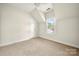 Attic bedroom featuring tan carpet and a bright window at 6201 Creola Rd, Charlotte, NC 28270
