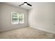 Bedroom features a ceiling fan, neutral carpeting and a bright sunny window at 6201 Creola Rd, Charlotte, NC 28270