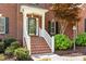 Close-up of the front door with white trim, brick steps, and manicured landscaping, creating a welcoming entrance at 6201 Creola Rd, Charlotte, NC 28270