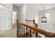 Upstairs hallway with railing, neutral carpet and pendant lighting at 6201 Creola Rd, Charlotte, NC 28270
