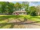 Charming single-story home with lush lawn, mature trees, and a classic brick facade at 627 Gray Dr, Charlotte, NC 28213