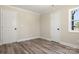 This bedroom has wood grain flooring, a window and a neutral color palette at 6525 Kershaw Camden Hwy, Heath Springs, SC 29058