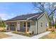 Charming home showing the covered front porch and an adjacent small deck, surrounded by a green lawn at 6525 Kershaw Camden Hwy, Heath Springs, SC 29058
