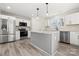 Modern kitchen featuring white cabinets, stainless steel appliances, a center island and light wood-look floors at 6525 Kershaw Camden Hwy, Heath Springs, SC 29058