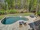 Aerial view of the private backyard featuring a kidney-shaped pool with tanning ledge and hot tub at 712 Chase Ct, Fort Mill, SC 29708