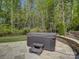 Outdoor hot tub on a stone patio with a wooded view, offering a private and relaxing experience at 712 Chase Ct, Fort Mill, SC 29708