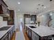 Open-concept kitchen with a marble-topped island, stainless steel appliances, and elegant dark cabinetry at 712 Chase Ct, Fort Mill, SC 29708
