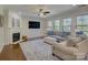 Spacious living room features fireplace, hardwood floors, a ceiling fan, and large windows at 712 Chase Ct, Fort Mill, SC 29708