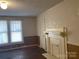 Bedroom with wood paneling, bright windows, a vintage fireplace, and decorative wallpaper accent at 8350 Nc Hwy 90 E Hwy, Stony Point, NC 28678