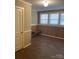 Bedroom featuring a built-in bench, three bright windows, classic wood paneling, and neutral walls at 8350 Nc Hwy 90 E Hwy, Stony Point, NC 28678