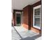 Close-up of the entryway with a storm door, red brick, a window, and a gray floor at 8350 Nc Hwy 90 E Hwy, Stony Point, NC 28678