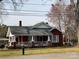 Charming brick bungalow-style home with a covered front porch and white railings at 8350 Nc Hwy 90 E Hwy, Stony Point, NC 28678