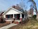Quaint brick home featuring a welcoming front porch with white columns and a brick staircase at 8350 Nc Hwy 90 E Hwy, Stony Point, NC 28678