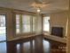 Bright living room with hardwood floors, a brick fireplace, and large windows for natural light at 8350 Nc Hwy 90 E Hwy, Stony Point, NC 28678
