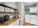 Well-organized laundry room with wood countertop, shelving, and white cabinets at 8917 Chalkstone Rd, Charlotte, NC 28216