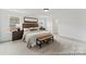 Bedroom featuring plush carpeting, a woven bench, decorative headboard, and serene natural light at 9913 Jack Nicklaus Dr # 908, Lancaster, SC 29720