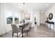 Sunlit dining room with wood table, gray upholstered chairs, large windows, and modern chandelier at 9913 Jack Nicklaus Dr # 908, Lancaster, SC 29720