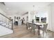 Open concept dining room with wood table, gray chairs, chandelier, and open views to the kitchen at 9913 Jack Nicklaus Dr # 908, Lancaster, SC 29720