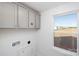 Bright laundry room with gray cabinets, tile floor, and a window providing natural light at 9913 Jack Nicklaus Dr # 908, Lancaster, SC 29720
