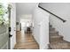 Inviting entryway with wood floors, staircase, and views of the dining area and kitchen at 10031 Travis Floyd Ln, Charlotte, NC 28214