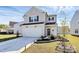 Charming two-story home featuring a well-manicured lawn, attached garage, and welcoming front entrance at 10031 Travis Floyd Ln, Charlotte, NC 28214