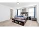 This main bedroom features carpet and a ceiling light as well as a modern headboard and plentiful natural light at 10031 Travis Floyd Ln, Charlotte, NC 28214